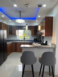 a kitchen with two chairs and a blue ceiling at Hermoso Apartamento con Jacuzzi Privado in Punta Cana