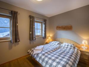 a bedroom with a bed and two windows at Chalet in Königsleiten near Ski Lift in Wald im Pinzgau +12 photos
