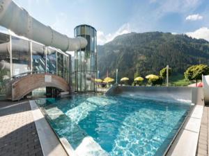 a swimming pool in front of a building with a mountain at Chalet in Königsleiten near Ski Lift in Wald im Pinzgau