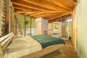 レザンセス・ダルレットにあるBungalow Ixora, bord de merの木製の天井の部屋にあるベッドのある寝室 +11枚の写真