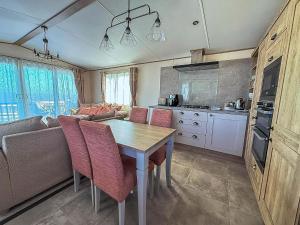 een keuken met een tafel en stoelen en een bank bij Beautiful Caravan With Stunning Sea Views At Haven Hopton Ref 80001H in Great Yarmouth