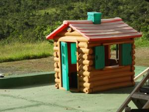 a small wooden toy house on a playground at Hotel Nautico in Três Marias