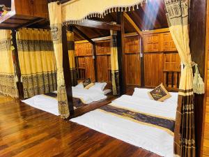 two beds in a room with wooden floors at Hà Giang Homestay in Lan Hung