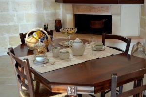 a dining room table with a wooden table with chairs and a fireplace at Casa Vittoria in Matera