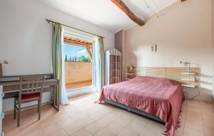 a bedroom with a bed and a desk and a window at Pet Friendly Home In Montauroux in Montauroux