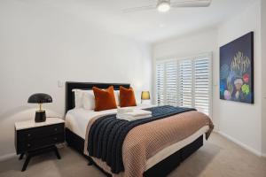 a bedroom with a large bed with orange pillows at NAIR6C - Central Freo Luxe Stay in Fremantle