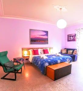 una camera da letto con un letto, una sedia e un divano di Nonno Francesco rooms a Catania