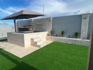 an outdoor bar with an umbrella and green grass at Hermoso Apartamento con Jacuzzi Privado in Punta Cana +10 photos