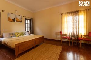 a bedroom with a bed and a table and chairs at Three Rivers by VEO - Part of StayVista in Jambur