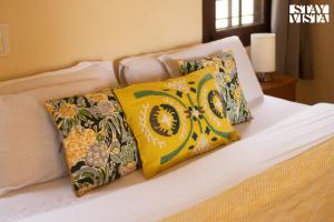 a bed with four pillows on it with at Three Rivers by VEO - Part of StayVista in Jambur