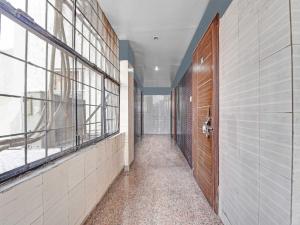 アジメールにあるOYO 85212 Hotel Vaibhavの木製のドアと窓のある廊下