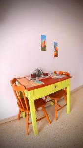 un tavolo giallo con due sedie davanti a un muro di Nonno Francesco rooms a Catania