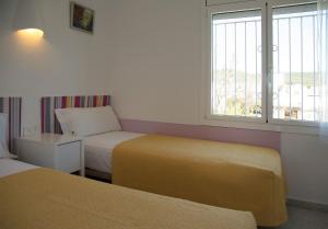 ein Hotelzimmer mit zwei Betten und einem Fenster in der Unterkunft Ferienhaus Casa Fluvià mit Gemeinschaftspool in L'Estartit in Torroella de Montgrí + 20 Fotos