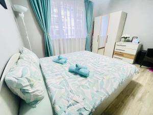 a bedroom with a bed with two blue pillows on it at By The Sea - central with free parking in Varna City