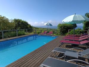 una piscina con sedie e un ombrellone di Casa Do Tanque a Nordestinho