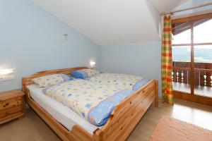 a bedroom with a bed with a wooden frame and a window at Wellness Ferienwohnungen Zellertalblick in Drachselsried +46 photos