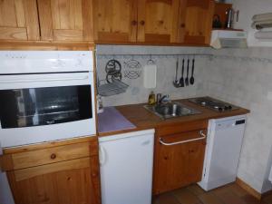 una cucina con armadi in legno e un piano cottura bianco con forno di Studio confortable au Sauze, proche pistes, 4 couchages - FR-1-804-53 a Enchastrayes