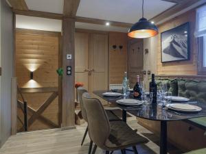 a dining room with a table and chairs with wine bottles at Courchevel 1850: Duplex charmant 6 pers près centre, parking, wifi - FR-1-631-228 in Courchevel +6 photos