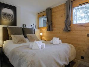 a bedroom with a large bed with pillows on it at Courchevel 1850: Duplex charmant 6 pers près centre, parking, wifi - FR-1-631-228 in Courchevel