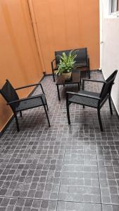 three black chairs and a potted plant on a patio at La casa in Gualeguaychú