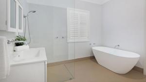 a white bathroom with a tub and a sink at Somerset in Robertson