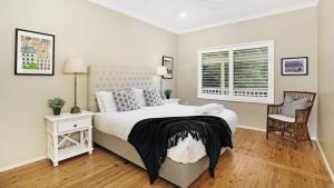 a bedroom with a bed and a chair and a window at Somerset in Robertson