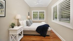 a white bedroom with a bed and a window at Somerset in Robertson