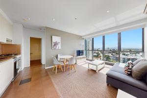 a living room with a couch and a table with chairs at Cloud 17 Retreat - Meriton Soleil Private Apt 1B in Brisbane