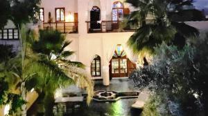 a large house with a pond in front of it at Riad Lotus Bleu in Fès +13 photos