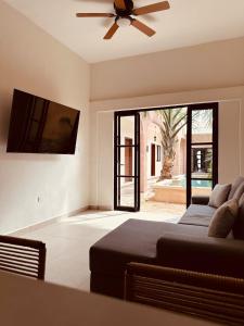 a living room with a couch and a ceiling fan at Casa Ámbar, tu casa en Mérida in Mérida