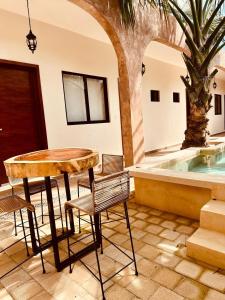 a table and chairs in a room with a pool at Casa Ámbar, tu casa en Mérida in Mérida