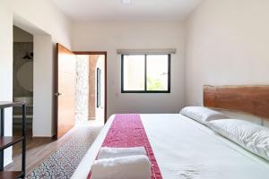 a bedroom with a large bed and a window at Casa Ámbar, tu casa en Mérida in Mérida +76 photos