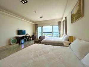 a hotel room with two beds and a desk at 都蘭那界灣海景民宿 in Donghe