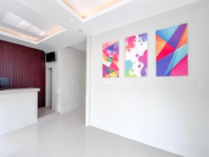 a room with three paintings on the wall at RedDoorz Syariah near Alun-Alun Tanjunganom Nganjuk in Warujayeng +52 photos