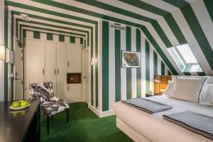 a hotel room with a bed and a chair at Room Mate Collection Valeria, Málaga in Málaga