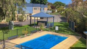 a swimming pool with a gazebo in a yard at Brooklya by the Beach in Cowes