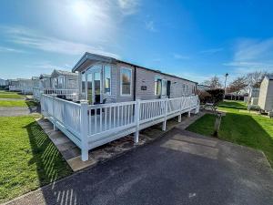een stacaravan met een veranda en een veranda bij Stunning Caravan With Decking At Haven Hopton-On-Sea Ref 80007L in Great Yarmouth