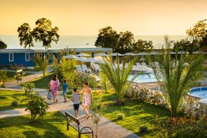 grupa ludzi chodzących po ośrodku w obiekcie Aminess Planet Camping Holiday Homes Maravea w mieście Novigrad