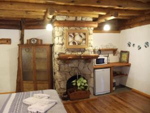 uma cozinha com uma lareira de pedra num quarto em Patagonia Playa Suites em Mar de las Pampas