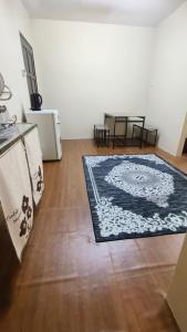 a living room with a rug on a wooden floor at Cinta Homestay Satu UTHM in Parit Raja +3 photos