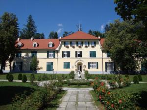 a large white house with a garden in front of it at Vila Rogaška in Rogaška Slatina