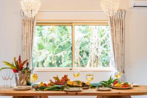 a table with food and wine glasses in front of a window at ファミリーハウスいさがわ in Isagawa