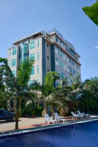 un grande edificio con sedie e una piscina di Elanacha Hotel ad Arusha