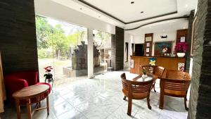 a living room with a table and chairs and a fireplace at Adhya Guest House in Tjakranegara