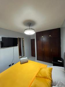 a bedroom with a large bed with a yellow blanket at Apartamento amueblado in Arenoso