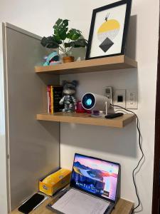 胡志明市FlexiHome的一张带书架的桌子上的笔记本电脑