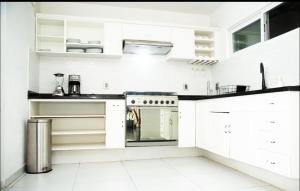 a white kitchen with white cabinets and a stove at Rió Tomatlán 1189 in Guadalajara