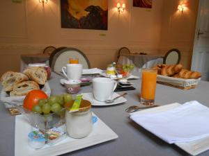 a breakfast table with bread and fruit and orange juice at Villa Léopoldine in Grenade-sur-Garonne