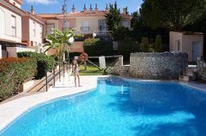 a young girl is standing in a swimming pool at Apartamento Islantilla in Islantilla