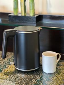 a black coffee pot and a cup on a table at Shangri-La Tanjung Aru, Kota Kinabalu in Kota Kinabalu